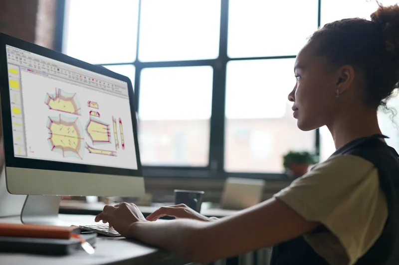 Modellista al lavoro su un cartamodello nel CAD di Lakeview